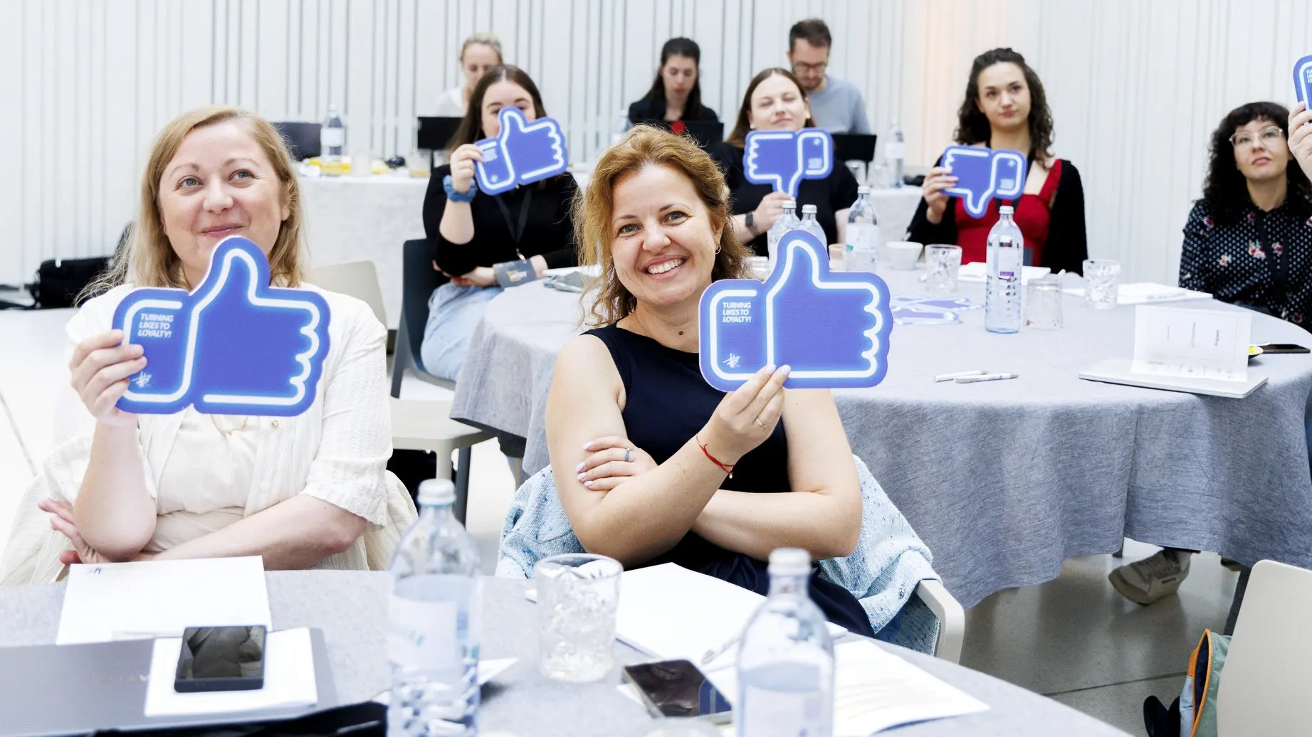 MediaBrothers Workshop mit Teilnehmenden und blauen Like- und Dislike-Schildern